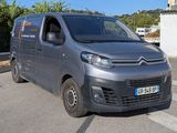 une camionnette Citroën garée sur le bord de la route, devant un immeuble