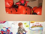 a cardboard box with a spider - man toy on top of it