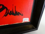 une image représentant un tableau d'un oiseau rouge et noir sur fond rouge