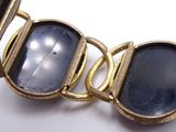 a close up of a bracelet with a black stone on it