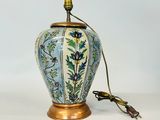 une image représentant un vase bleu et blanc avec un socle en laiton