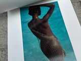 a photo of a woman in a fishnet bikini laying on the ground