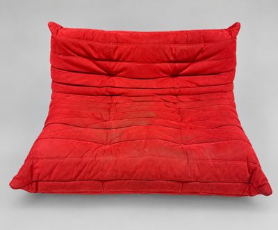a red futon chair with a pillow on top of it