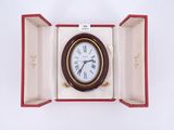 une horloge qui se trouve dans une boîte posée sur une surface blanche