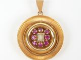 an image of a gold pendant with a pink stone in the center