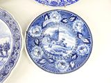 three blue and white plates sitting on a table