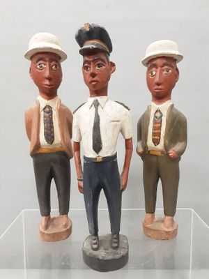 trois figurines représentant trois hommes portant un chapeau et une cravate