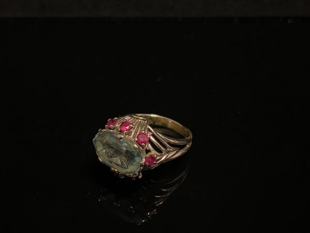 Bague en or gris à décor d’une aigue marine ovale facettée ceint ...