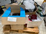 deux cartons contenant des articles posés sur une palette, accompagnés d'une étiquette de prix
