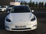 une voiture blanche garée dans un parking à côté d'autres voitures