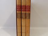 three books are stacked on top of each other on a white surface