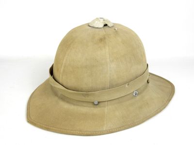 chapeau en cuir beige orné de boucles métalliques sur fond blanc