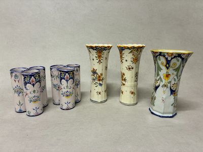 quatre vases sont alignés sur une surface blanche