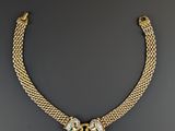 a gold and diamond necklace on a black background