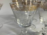 four wine glasses are lined up on a white table