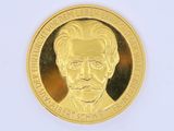 un gros plan d'une pièce d'or à l'effigie d'un homme