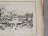 drawing of a river scene in a gold frame on a gray surface