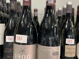 several bottles of red wine are lined up on a counter
