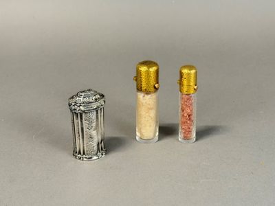 three salt and pepper shakers sitting next to each other