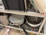 many pots and pans on the shelf in the kitchen