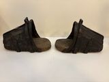 une paire de pantoufles en cuir noir sur une surface blanche