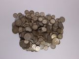 une pile de pièces d'argent sur une surface blanche