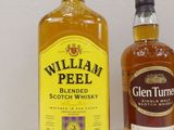 two bottles of whiskey sitting next to each other on a table
