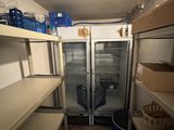 a refrigerator in the middle of a room with a lot of shelves