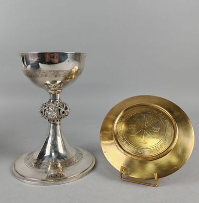 deux gobelets en argent et en or et une assiette en or posés sur une table
