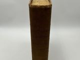 a brown vase that has a book on top of it