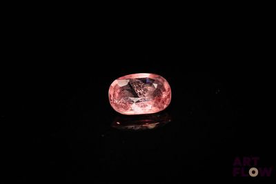 un diamant rose sur une surface noire