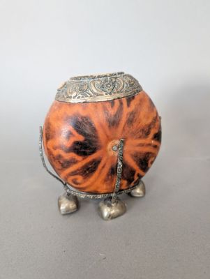 un petit objet en métal orné d'un motif représentant un tigre