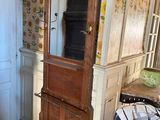 a tall wooden cabinet with a mirror on top of it