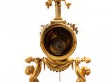 a gold clock that is sitting on top of a stand