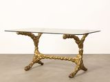 an image of a glass table with gold metal legs and a glass top