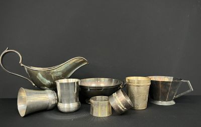 plusieurs tasses et soucoupes en argent posées sur une table avec un fond noir