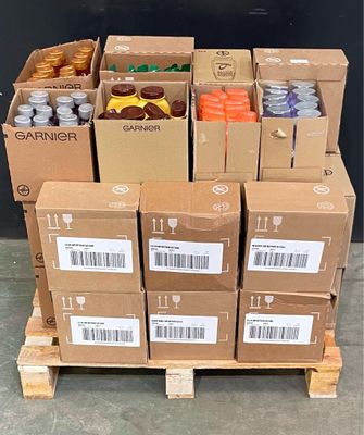 several boxes of sodas are stacked on a pallet in front of a black wall