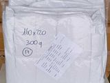 un sac de serviettes blanches posé sur une table blanche