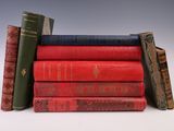 several books are stacked on top of each other on a white surface