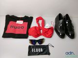 un sac noir, une chemise rouge, une paire de chaussures et une paire de lunettes de soleil posés sur une table