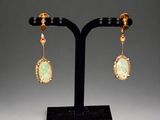 a pair of gold and jade earrings
