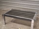 a metal bench sitting in front of a garage door