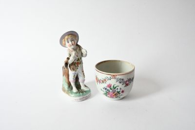 porcelain figurine of a boy and a cup on a white surface