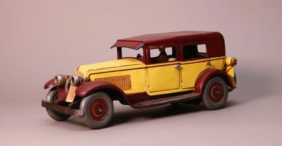 une petite voiture jaune et rouge sur fond gris
