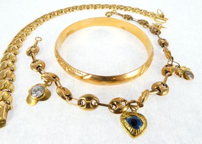 a gold bracelet and a bracelet with a blue stone on it