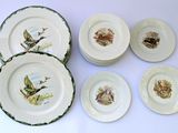 six plates with birds painted on them sitting on a table