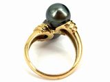 a close up of a ring with a black pearl on it