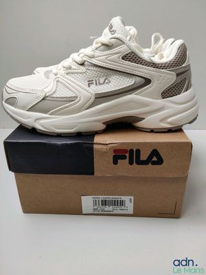 Les baskets Fila sont dans une boîte posée sur une table.