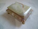 une boîte en marbre posée sur une table recouverte d'une nappe blanche