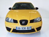 a yellow car that is parked in a white room